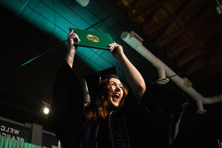 周六，<a href='http://kgfn.lscarpet.net'>和记棋牌娱乐</a>的一名毕业生在毕业典礼上展示她的毕业证书.